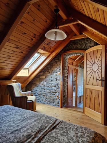 a bedroom with a bed and a stone wall at Zora Vendégház in Tihany