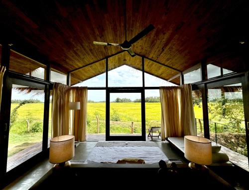 a living room with a couch and a large window at Ranakeliya Lodge - Yala in Yala