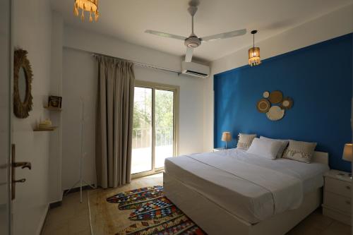 a bedroom with a large bed with a blue wall at calming valley in Luxor