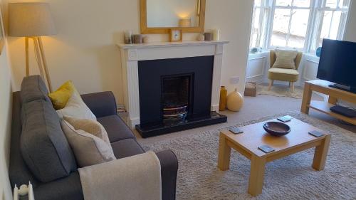 a living room with a couch and a fireplace at Turret View - spacious central location in Peebles