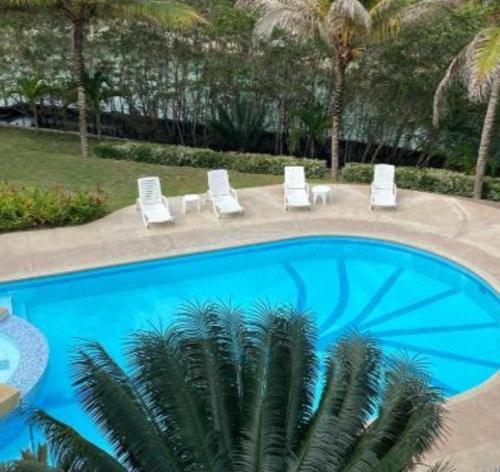 ein Swimmingpool mit Liegestühlen und einer Palme in der Unterkunft Torres del mar in Same