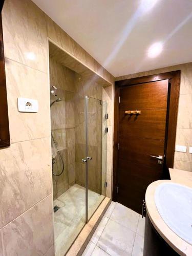 a bathroom with a shower and a glass door at Sabina 2BD with pool and lagoon view in Hurghada