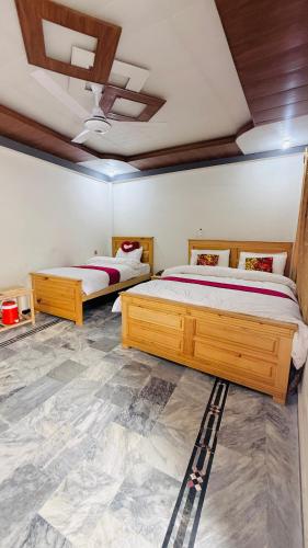 a bedroom with two beds and a ceiling at Kaka G Hotel Utror Valley in Utrot