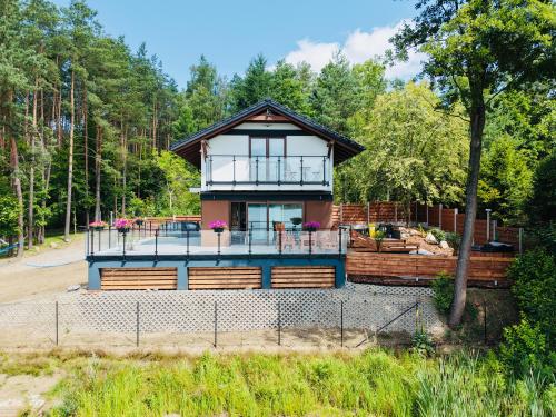 a house in the woods with a balcony at Szept Wody Kaszuby in Lubiana