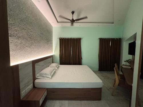 a bedroom with a bed and a ceiling fan at HOTEL SREE DURGA in Kolkata