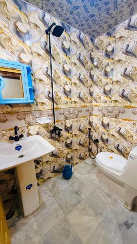 a bathroom with a sink and a toilet and a tv at Kaka G Hotel Utror Valley in Utrot