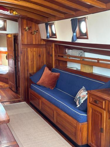 a blue couch in a room on a boat at Argovia Dutch Barge in Brightlingsea