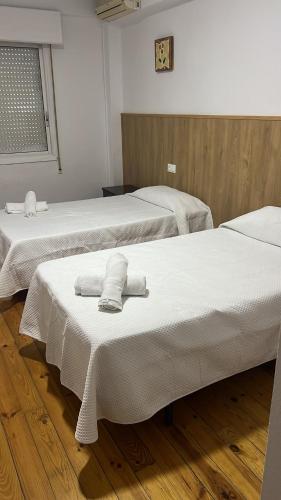 two beds with towels on them in a room at Hotel Termas Camino Real in Ourense