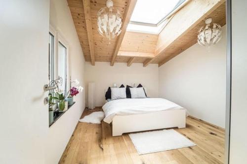 a bedroom with a white bed and a skylight at Tyrolhaus in Grinzens