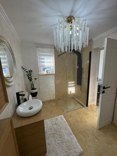 a bathroom with a sink and a chandelier at Talna Luna Ses in Negreşti-Oaş