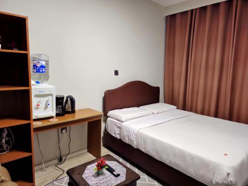 a hotel room with a bed and a desk and a table at JKIA Transit Hub in Syokimau