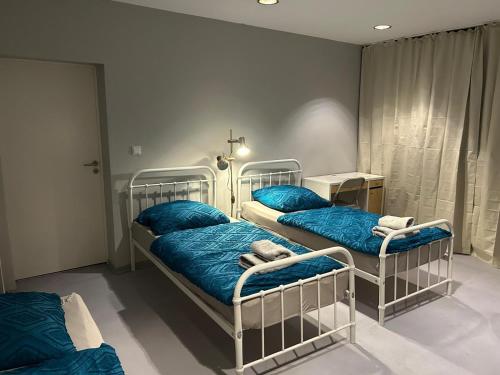two beds in a room with blue blankets and pillows at Freedom Studio Apartment in Berlin