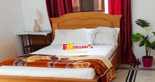 a bedroom with a bed with a sign on it at Appart meublé Excellentia Edea in Edéa