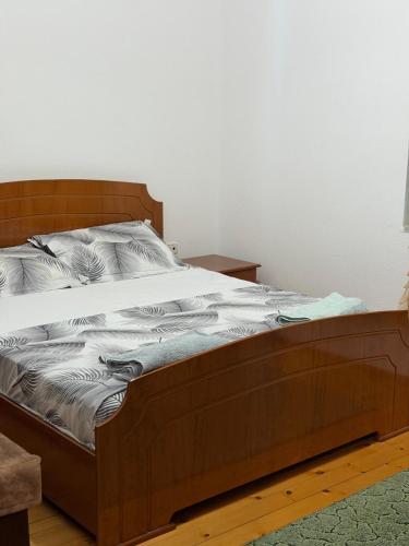 a bed with a wooden frame in a bedroom at Green House in Pogradec