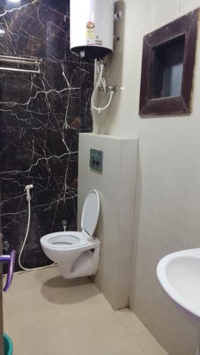 a bathroom with a toilet and a sink at Hotel Urban Stay - Mathura in Mathura