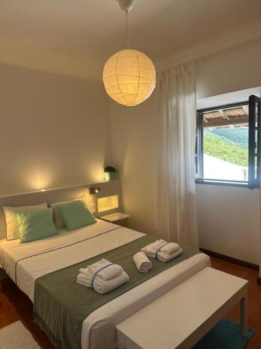 a bedroom with a bed with towels on it at Casal Mala-Posta in Rio Maior