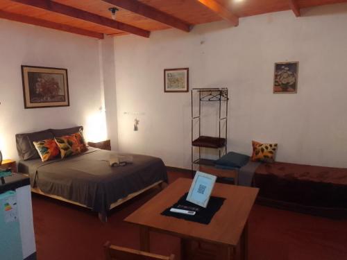 a bedroom with a bed and a table with a laptop at Departamento Monoambiente-Selva Stay Iguazu in Puerto Iguazú