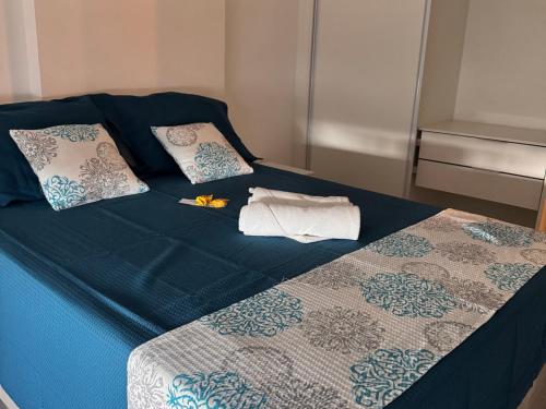 a bed with blue sheets and pillows on it at Studio Design 3 - 409 in Maceió