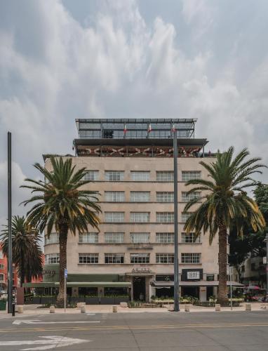 ein großes Gebäude mit Palmen davor in der Unterkunft Hotel More By Kavia in Mexiko-Stadt