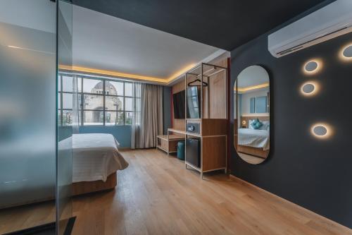 ein Schlafzimmer mit einem Bett und einem Spiegel in der Unterkunft Hotel More By Kavia in Mexiko-Stadt