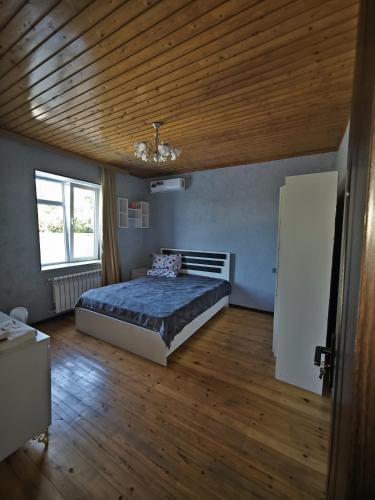 a bedroom with a bed and a wooden ceiling at Qebele Romi Family House in Vǝndam