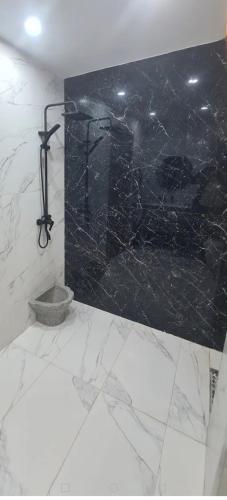 a bathroom with a black and white marble wall at Nassim19 in Sétif