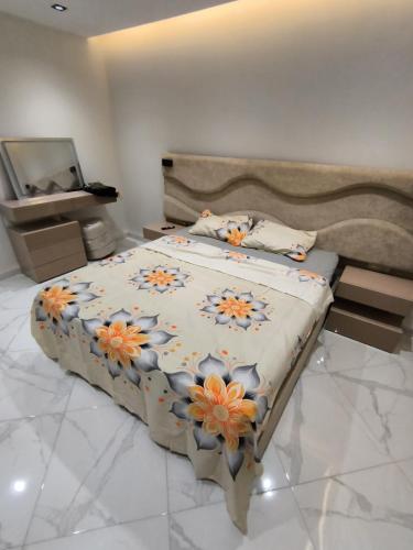 a bedroom with a large bed with flowers on it at Nassim19 in Sétif