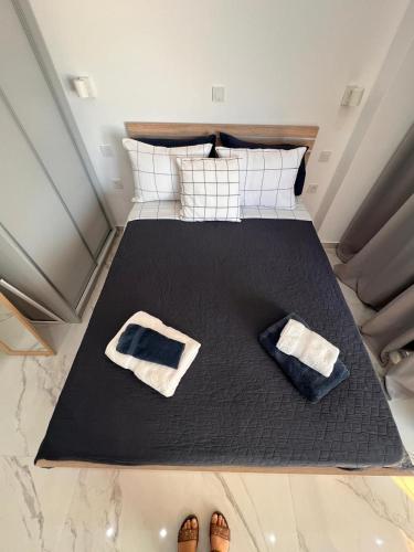 a bedroom with a bed with two pairs of shoes at Ble Property Atlas 6 in Loutraki
