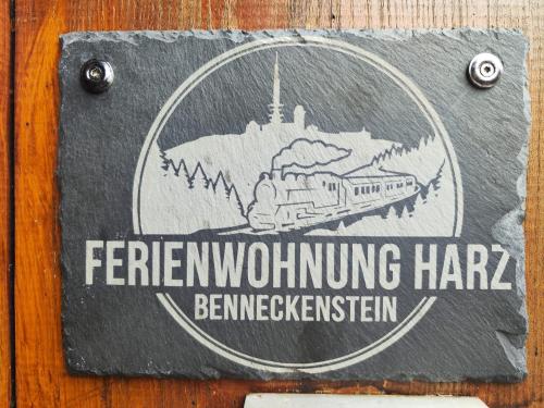 a sign on a wooden table with a train on it at Fewo HARZ Benneckenstein in Benneckenstein