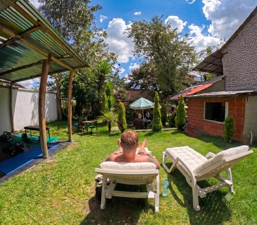 a man sitting in a chair in the yard at Colonial House Inn in Quito