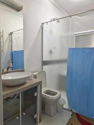a bathroom with a sink and a toilet and a shower at Refúgio triplo por pessoa in Paulínia
