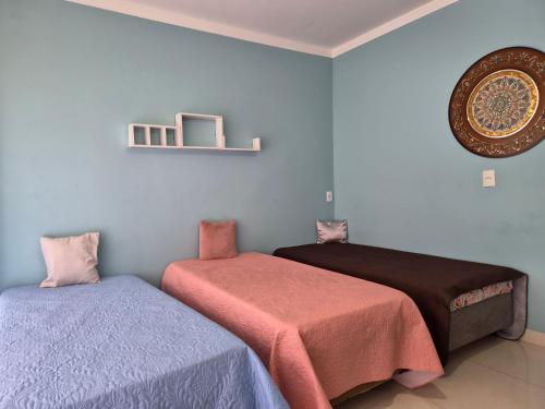 a bedroom with two beds and a picture on the wall at Refúgio triplo por pessoa in Paulínia