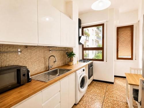 a white kitchen with a sink and a dishwasher at Savona Casa Dolce Vita in Savona