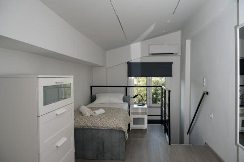 a white bedroom with a bed and a window at Angels luxury villa in Kastamonítsa