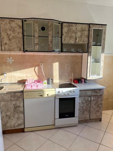 a kitchen with a white stove and a sink at Studio apartman Delic in Podgorica