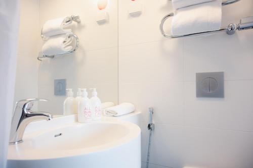 a bathroom with a sink and a mirror at Omena Hotel Helsinki Lönnrotinkatu in Helsinki