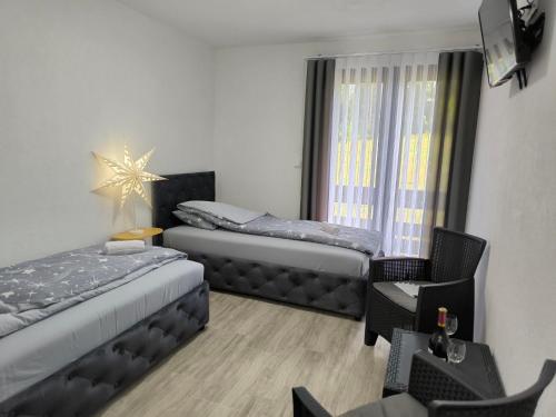 a small room with two beds and a window at Hotel Vuković in Han Pijesak