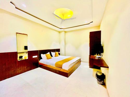 a hotel room with a bed and a mirror at Shree Gurukripa Inn in Maheshwar
