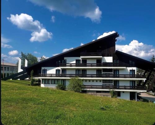 a large white building with a black roof at Hotel Vuković in Han Pijesak