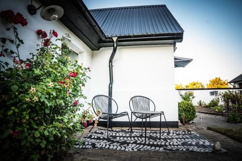 two chairs sitting on a patio next to a building at Pärla in Kåseberga in Löderup