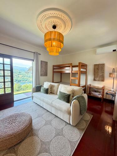 a living room with a couch and a bed and a chandelier at Miradouro 13 - Gerês in Geres