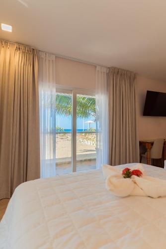 a bedroom with a bed with a view of the beach at Honduras Shores Plantations in Tela