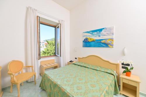 a bedroom with a bed and a large window at Hotel Villa Paradiso in Ischia Town