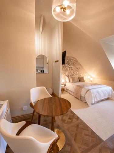 a bedroom with a bed and a table and chairs at Appartement Collection Sea View in Saint-Valéry-sur-Somme