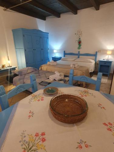 a bedroom with two beds and a table with a bowl on it at Palmas Anna's rooms Is Procilis in Palmas Arborea