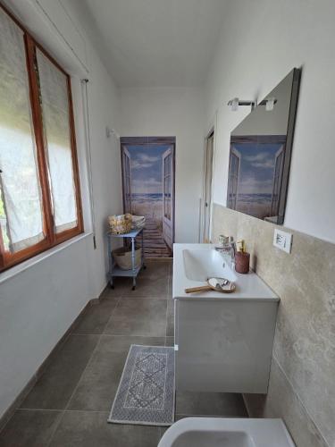a white bathroom with a sink and a mirror at FasHion HOme in Ameglia