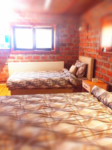 a bedroom with two beds and a brick wall at Lipora apartman in Vrnjačka Banja