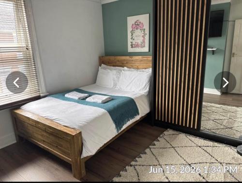 a bedroom with a bed with a wooden headboard at Luxurious Modern Town House in Gillingham