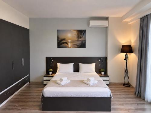 a bedroom with a large bed with two white towels at Batumi - Seaside Stunning Apartment in Batumi