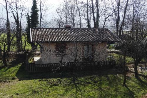 a small house with a fence in the grass at La Casetta in Dronero